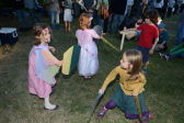 Chilren practice jousting among their peers on the lawn. 